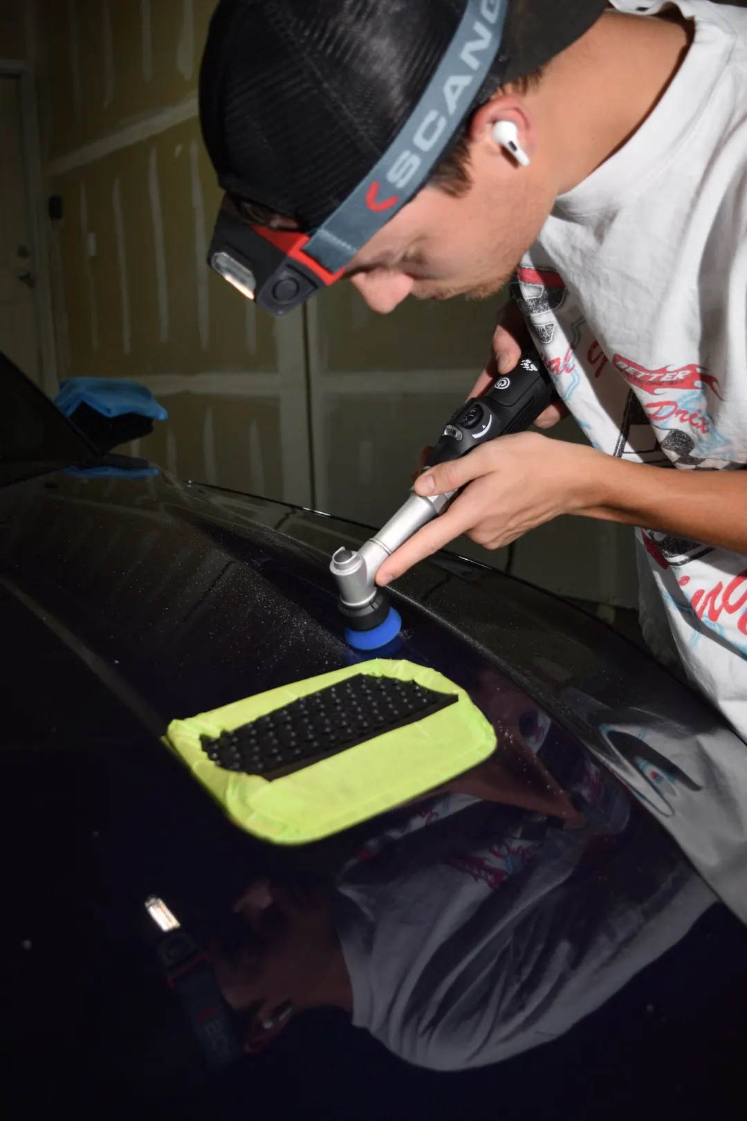 Landon Frost polishing paint with a headlamp